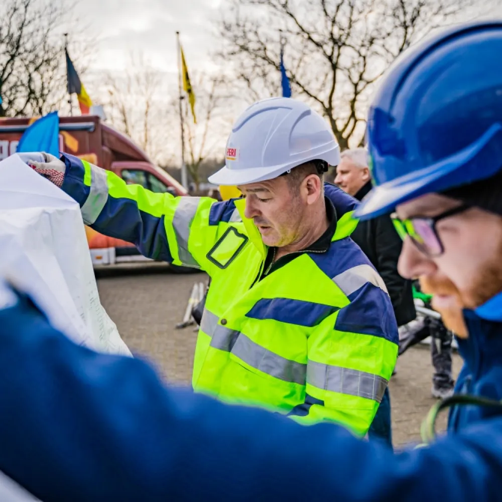 Twee mannen met helm en fluovestje op een bouwwerf