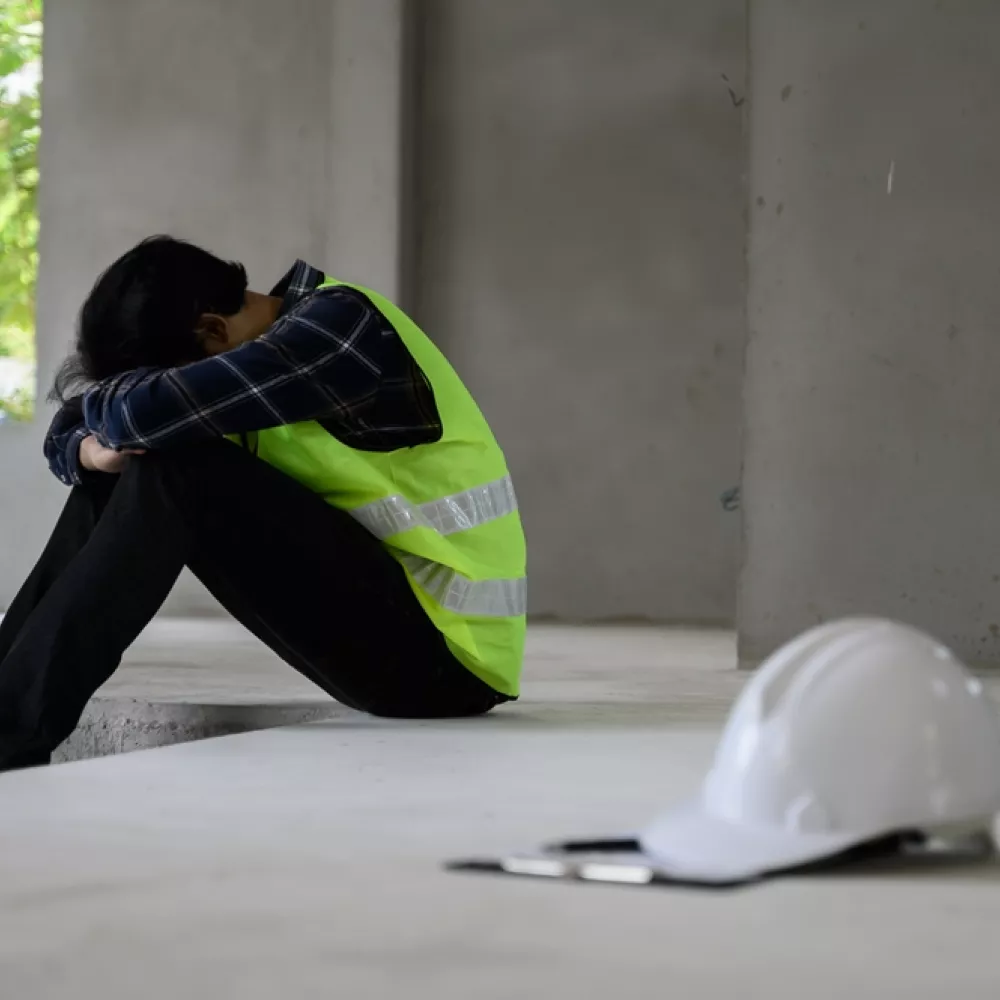 helm ligt naast een man die met de hoofd in de handen zit