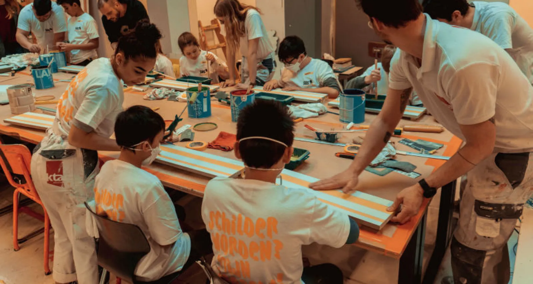 Kinderen die met verf spelen tijdens de actie SOS Schilders op School